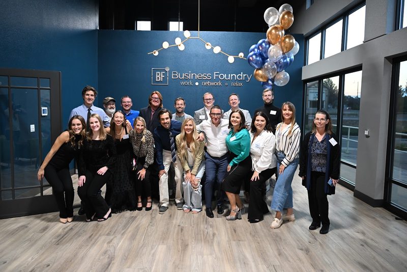 Members and guests gathered for a group photo in front of the Business Foundry sign at reception, balloons overhead