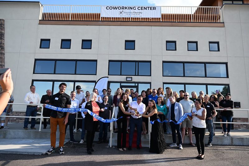A crowd outside the front of our business campus for the ribbon cutting, the Coworking Center sign above