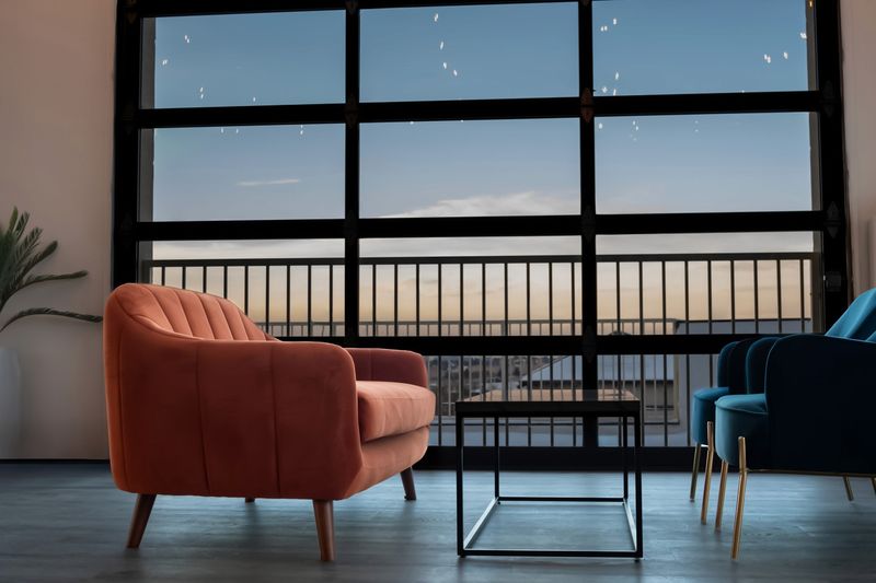 An orange armchair by the garage-door windows at dusk