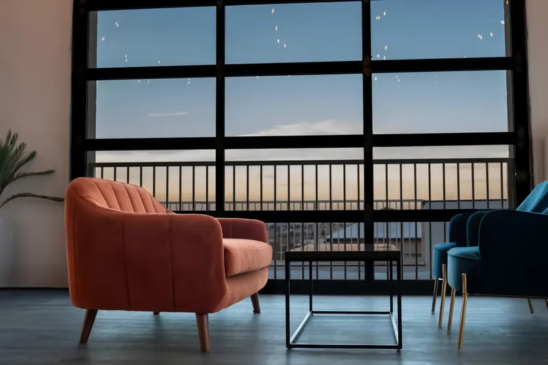 An orange armchair by the garage-door windows at dusk